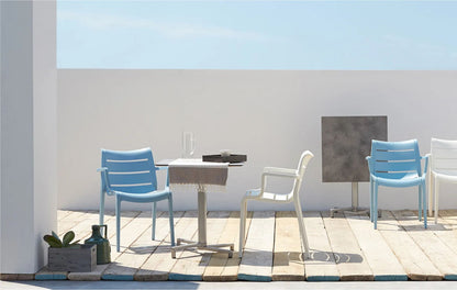 SCAB Sunset stackable outdoor armchairs around a café table on a modern terrace, suitable for residential and commercial outdoor spaces.