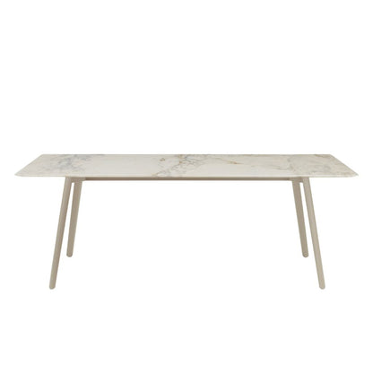 Front view of the S•CAB Squid M Marble Dining Table with a white marble-effect tabletop and matching light-coloured angled metal legs.