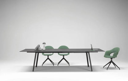 S•CAB Squid OF Office Meeting Table with a black tabletop, integrated cable management, and angled legs in a contemporary conference room with swivel chairs.