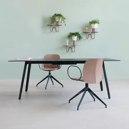 S•CAB Squid OF Office Meeting Table with a black tabletop and angled legs in a contemporary office meeting space paired with swivel office chairs.