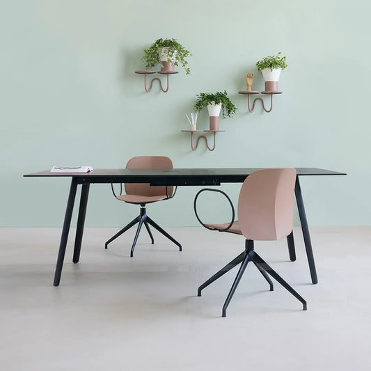 S•CAB Squid OF Office Meeting Table with a black tabletop and angled legs in a contemporary office meeting space paired with swivel office chairs.