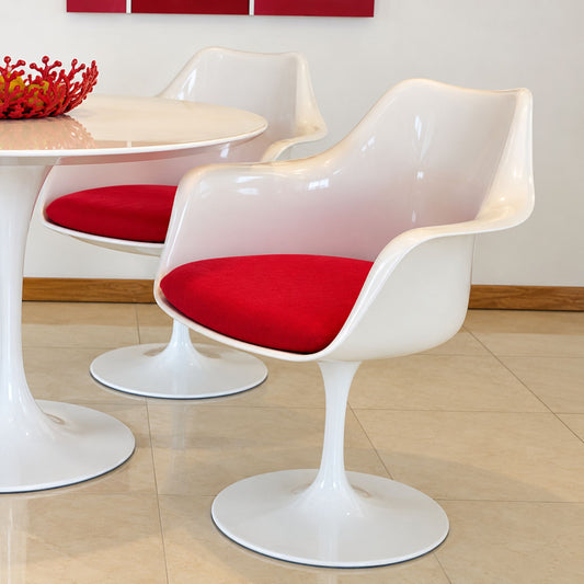 Pair of Tulip armchairs with white moulded shells, white pedestal bases and red upholstered seat cushions around a matching round Tulip dining table in a contemporary dining room, inspired by Eero Saarinen's iconic mid-century modern Pedestal Collection.
