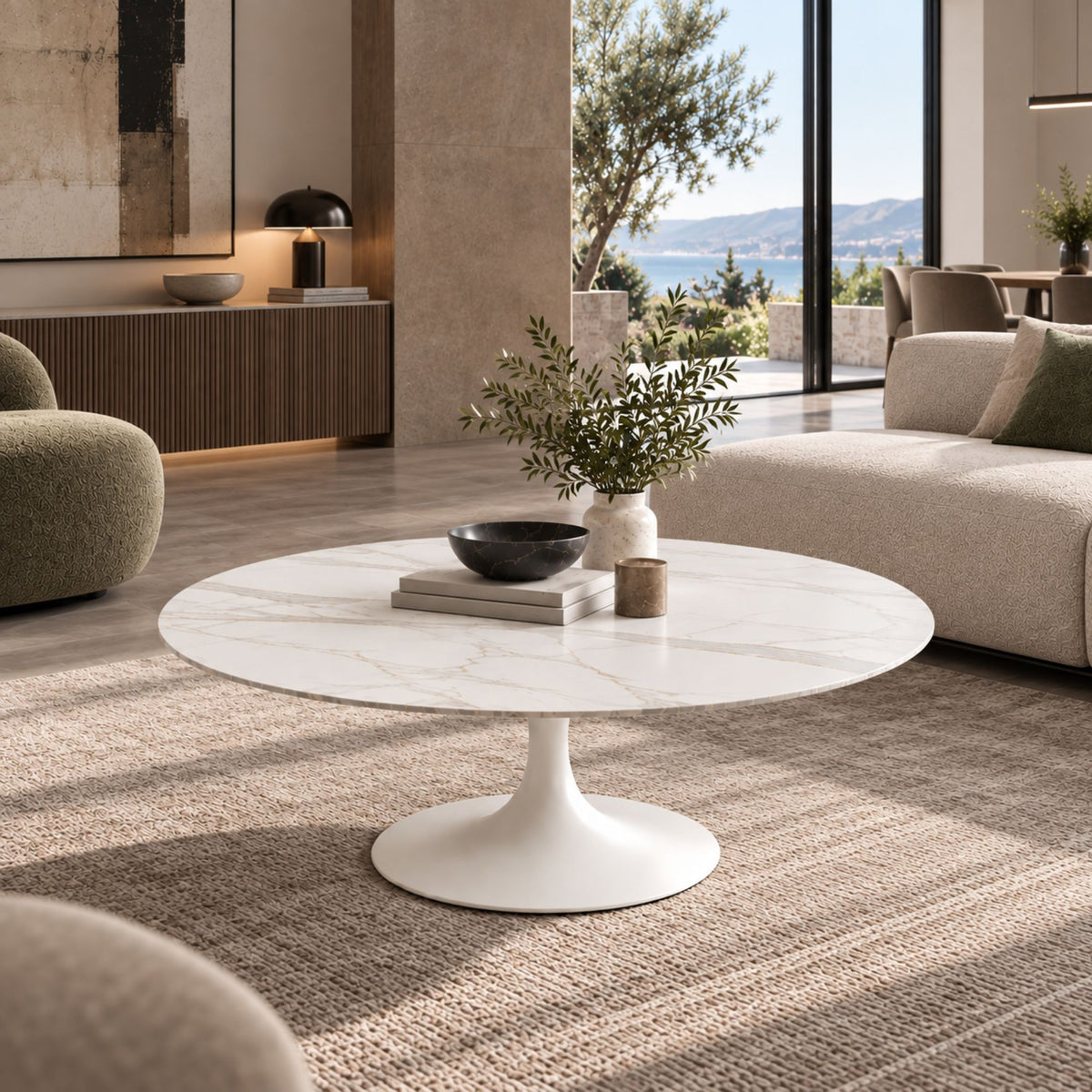 White marble-effect oval Tulip coffee table with a white pedestal base styled in a luxury modern living room with contemporary décor and natural daylight.
