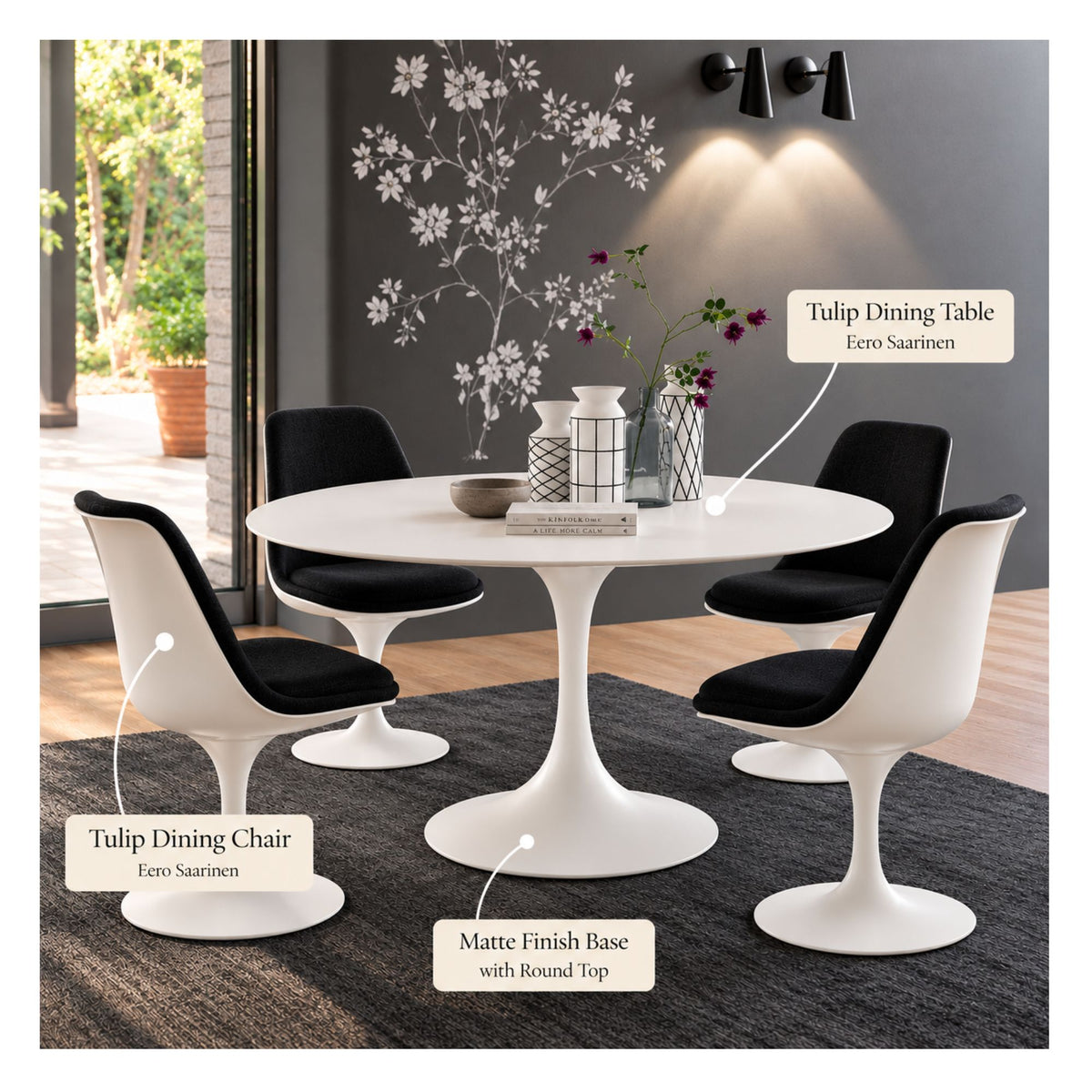 White round Eero Saarinen Tulip dining table with a white matte pedestal base paired with four black upholstered Tulip dining chairs featuring white shells in a modern dining room.