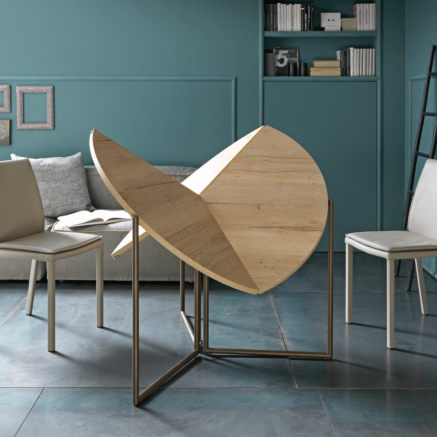 Altacom Icaro folding table mid-opening showing pivoting structure and folding round top