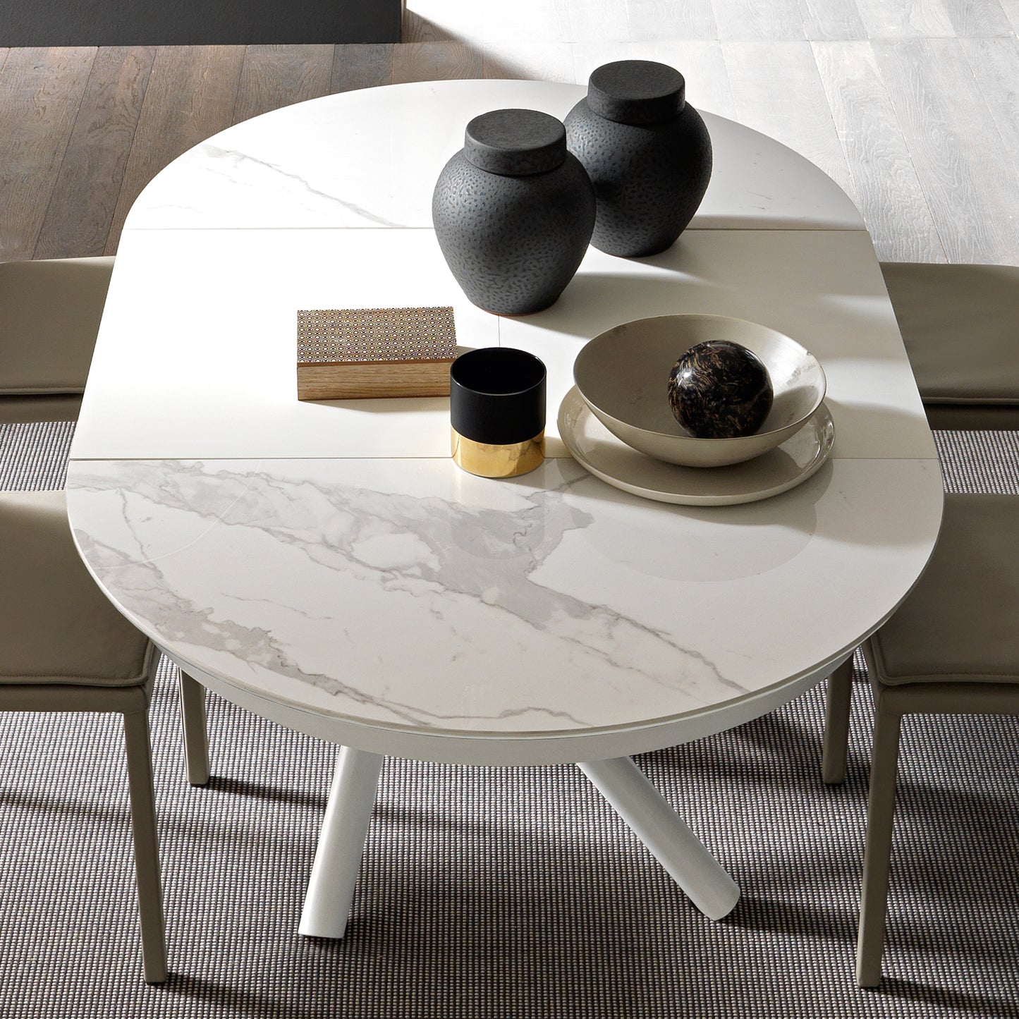 Top view of Helios extendable dining table by Altacom with white marble-effect ceramic top and white crossed metal base