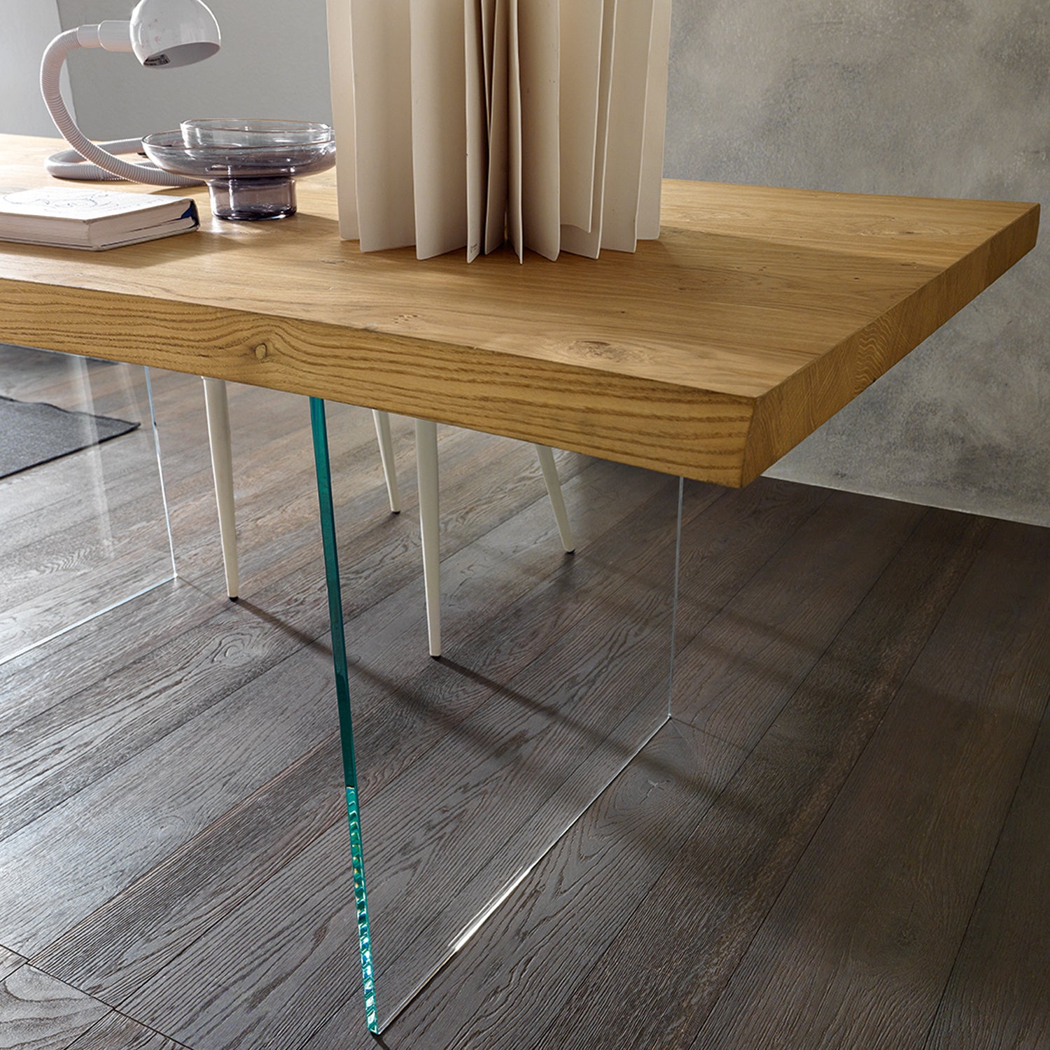 Meridiano dining table detail showing transparent glass legs and floating wood top effect by Altacom