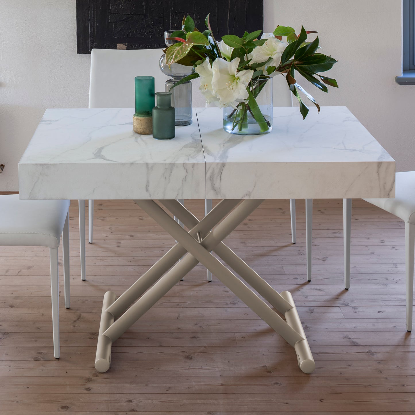 Ulisse convertible table by Altacom raised to dining height with marble effect top and metal cross base with chairs